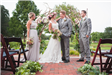 Bride, Groom, and Two Members of Wedding Party in Front of Wooded Archway